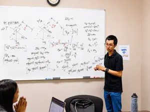 Instructor teaching physics lesson at a whiteboard