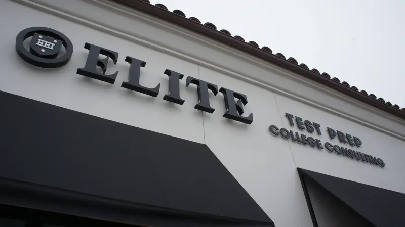 Storefront exterior sign reading "ELITE" with smaller lettering "Test Prep, College Consulting" below a tile roof.