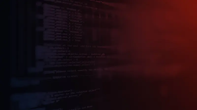 Blurred lines of computer code on a dark screen washed in red light