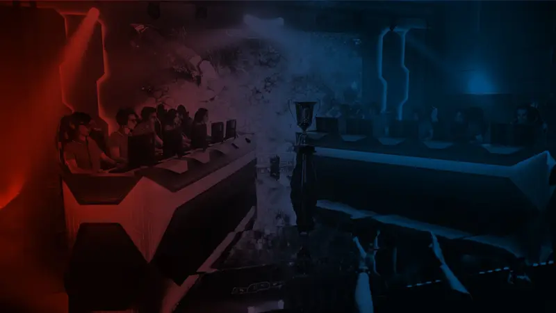 Rows of players at computers in a dark esports arena lit with red and blue light, trophy at center