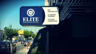 Storefront sign reading "Elite Educational Institute — Test Preparation, Academic Tutoring, College Consulting" above a city street.