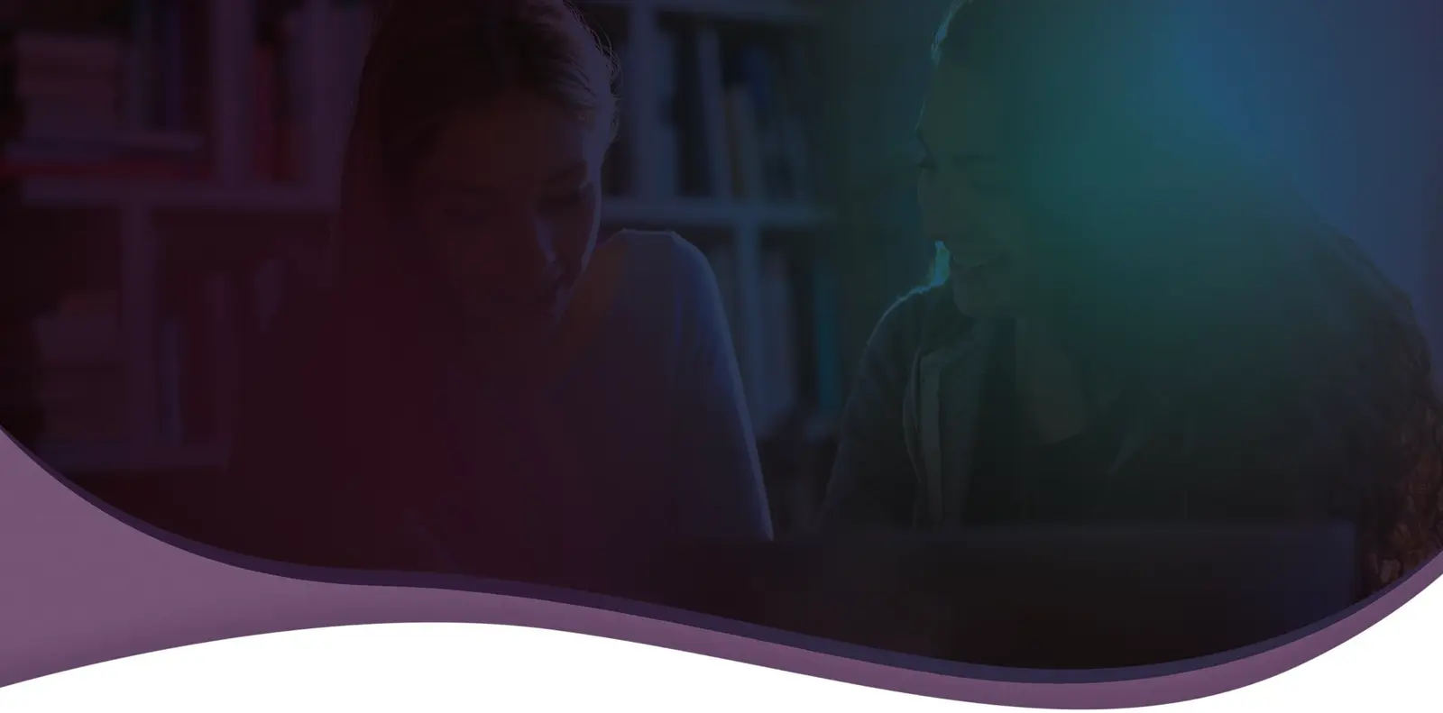 A tutor and a student working together at a table in front of bookshelves, under a dark purple overlay