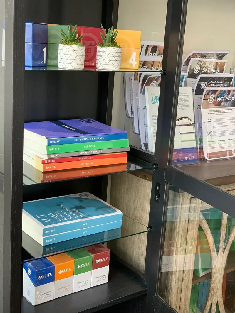 Shelves of Elite SAT and ACT prep books, vocabulary card boxes, and SAT Prep and ACT Prep brochures