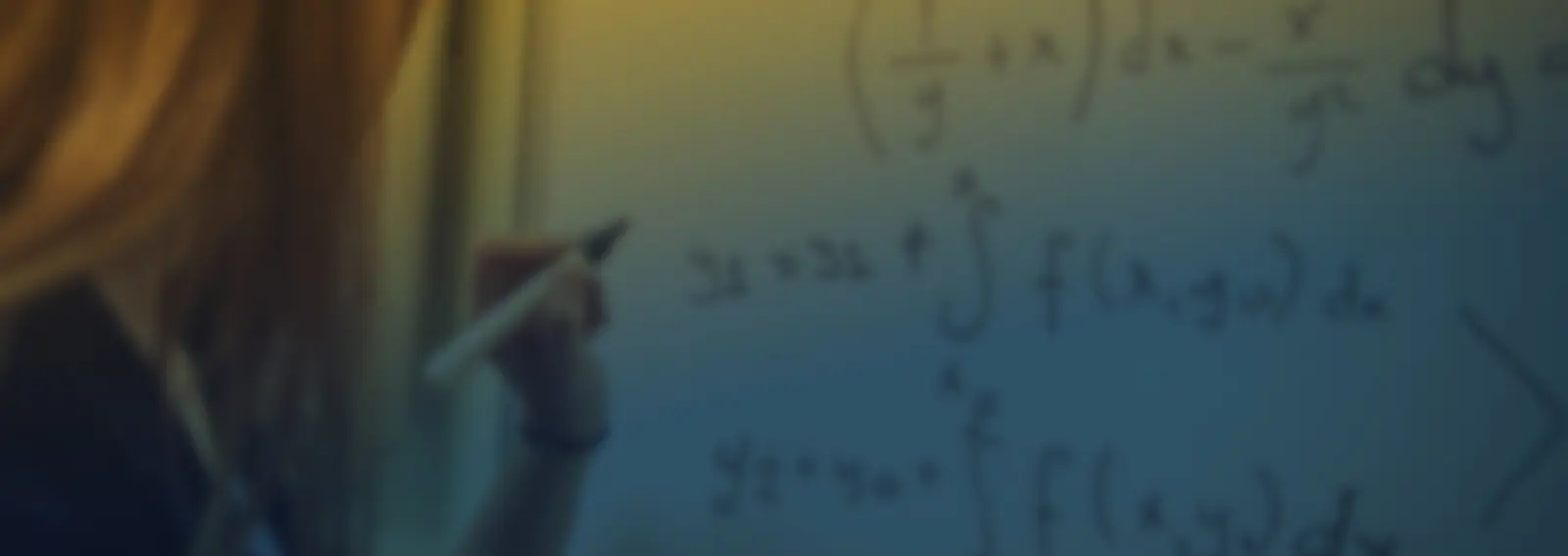 A student writing calculus equations with integrals on a whiteboard