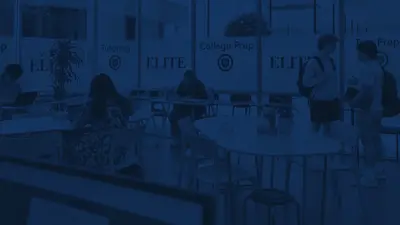 Students studying at tables in an Elite Prep center with windows labeled "Tutoring," "College Prep" and "Test Prep".