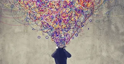Person seen from behind holding their head, with a tangle of colorful scribbled lines bursting out of it