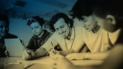 A tutor working through a problem with a group of students at a table
