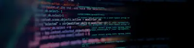 Close-up of colorful programming code displayed on a dark computer screen at an angle