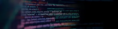 Close-up of colorful programming code displayed on a dark computer screen at an angle