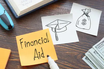 Orange sticky note reading "Financial Aid" beside sketches of a graduation cap and money bag, a marker, and cash.