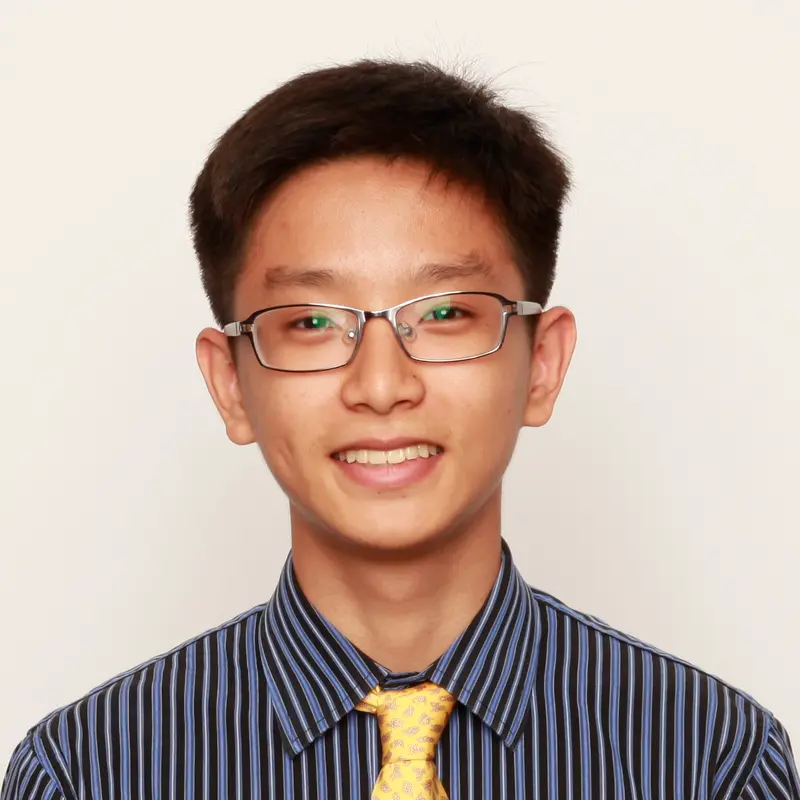 Smiling young man with glasses in a striped shirt and yellow patterned tie