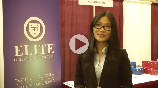 Video thumbnail of a smiling woman in a black blazer standing beside an "Elite Educational Institute" banner at an education fair booth.