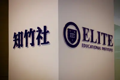 Wall signage with Chinese characters and the Elite Educational Institute crest logo