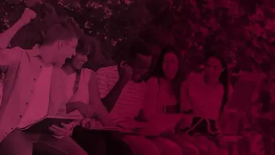 A group of students cheering together over their laptops outdoors